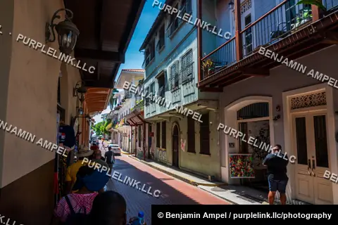 Casco Viejo, Panama City, Panama - August 2023: Tourists walk down a narrow colonial street lined with historic balconied buildings.