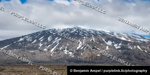 Snæfellsjökull glacier volcano rises with snow-streaked slopes above the Snæfellsnes lava plain, Iceland.