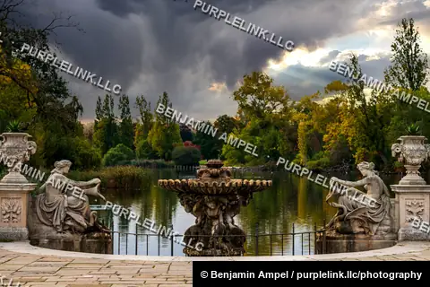 London, England - October 2025: Classical urns and reclining stone figures frame a scalloped fountain at the Italian Gardens in Hyde Park beneath dramatic storm clouds.