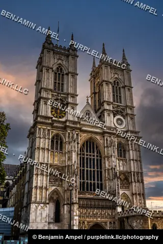 London, England - October 2025: The twin west towers of Westminster Abbey rise above autumn trees under dramatic evening clouds.