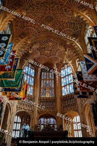 London, England - October 2025: Intricate fan vaulting and colorful heraldic banners hang above the Henry VII Lady Chapel inside Westminster Abbey.