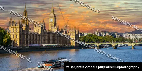 London, England - October 2025: A sightseeing boat travels along the River Thames past the Houses of Parliament and Big Ben under a vivid sunset sky.