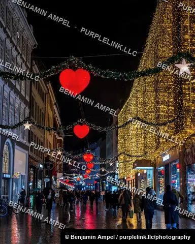 Copenhagen, Denmark - December 2025: The Hotel d'Angleterre facade is draped in string lights with a large decorated Christmas tree and gift boxes below its illuminated sign.