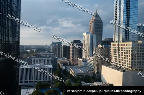 Atlanta's downtown skyline glows in golden evening light, framed by a distinctive pyramid-topped skyscraper.