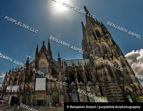 Cologne, Germany - June 2026: Visitors gather on the steps of Cologne Cathedral beneath its towering Gothic spires.
