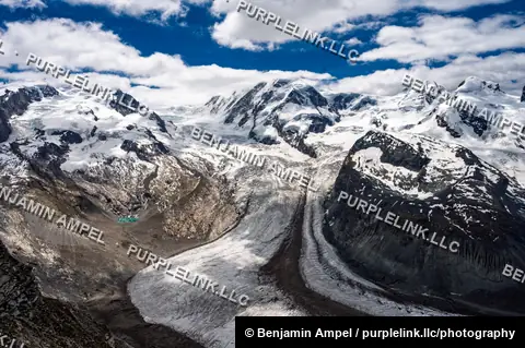 The Gorner Glacier winds between snow-covered peaks in a dramatic panorama of the Swiss Alps near Zermatt.