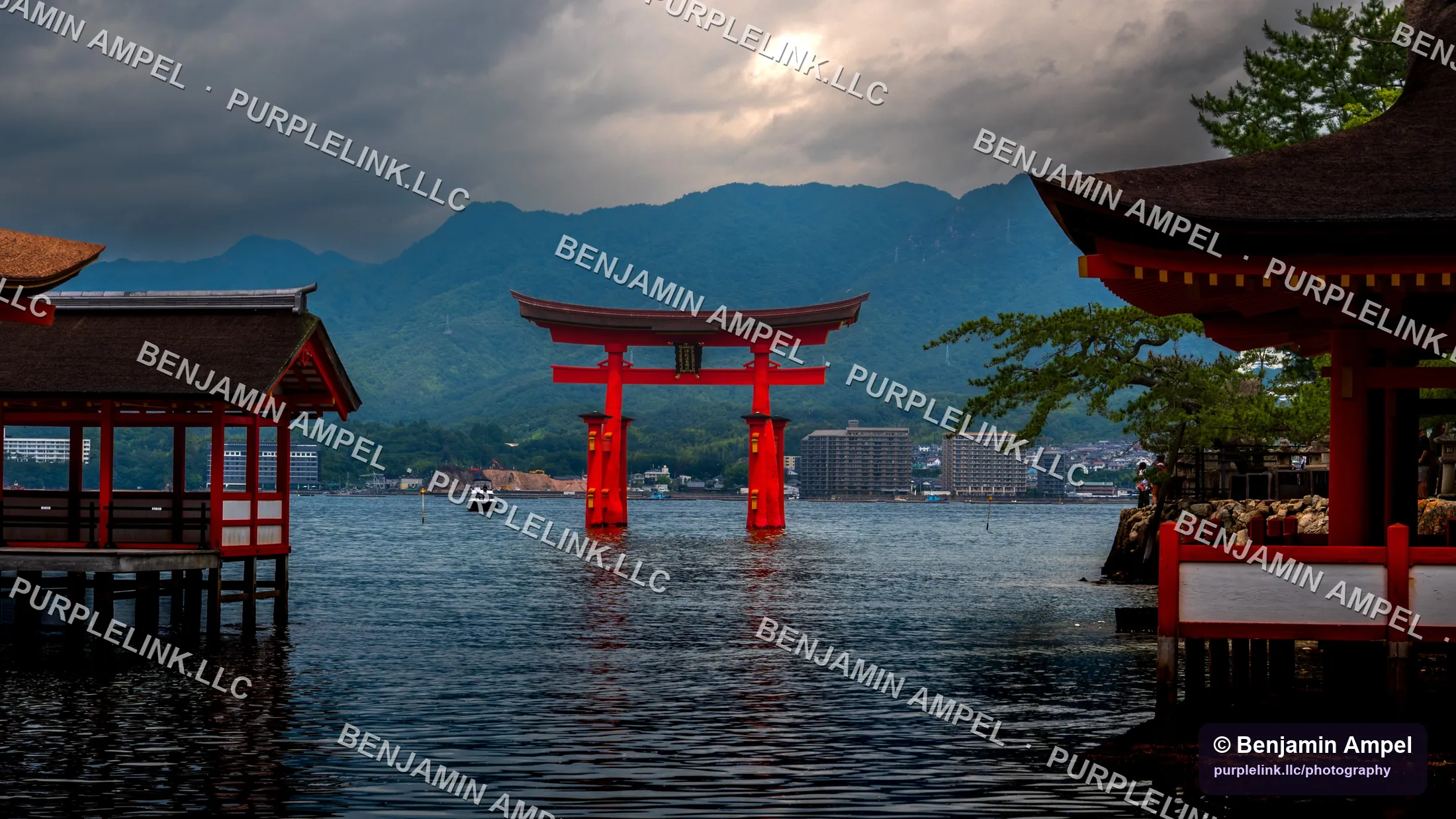 The red torii gate of Itsukushima Shrine standing in the sea at dusk beneath heavy clouds