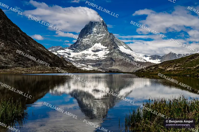The Matterhorn reflected in the still water of Riffelsee under a deep blue sky